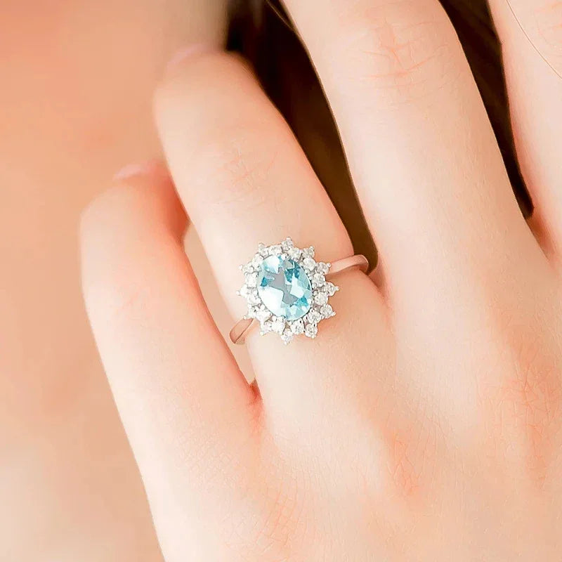 Oval Aquamarine Halo Ring styled hand view showing ring scale