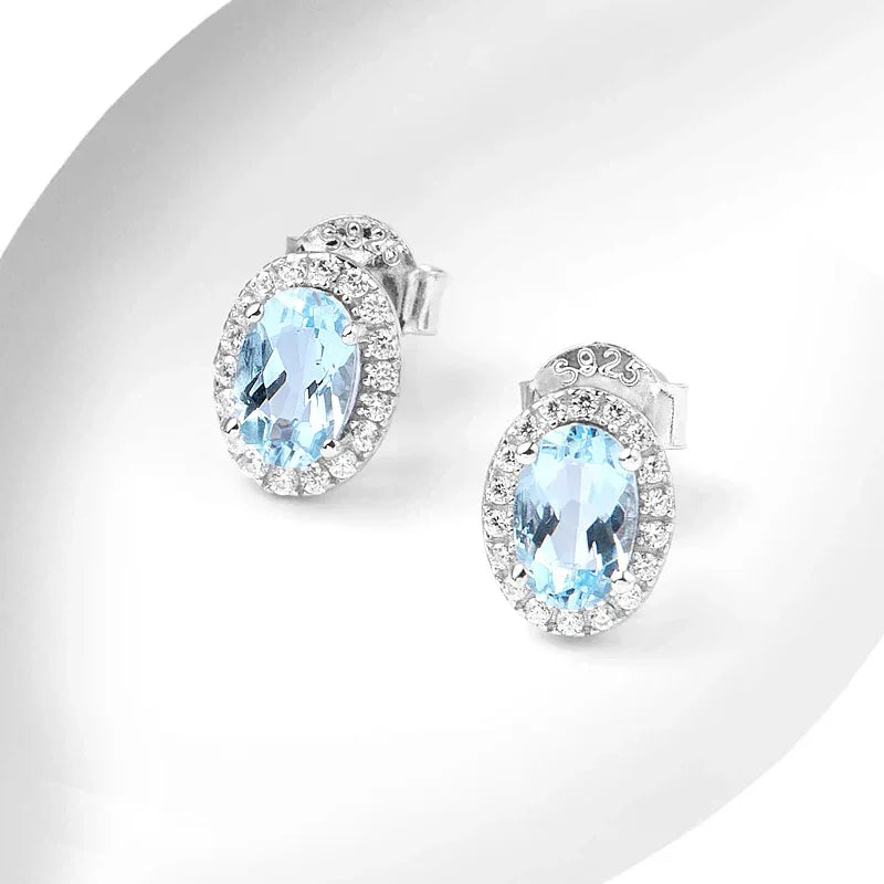Oval Aquamarine Halo Stud Earrings angled pair on a white background
