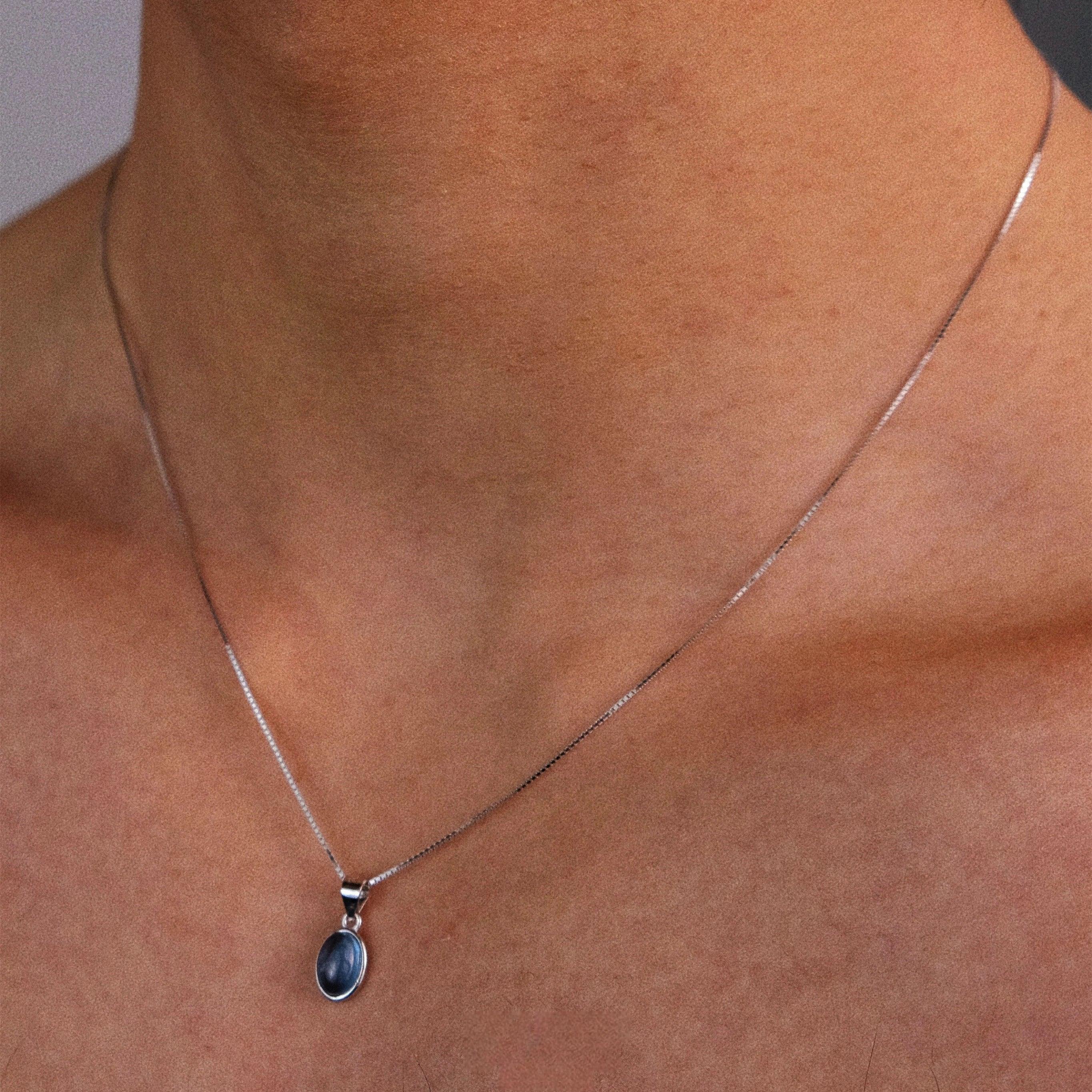 Oval Aquamarine Snake Chain Pendant Necklace worn at the neckline in a close-up