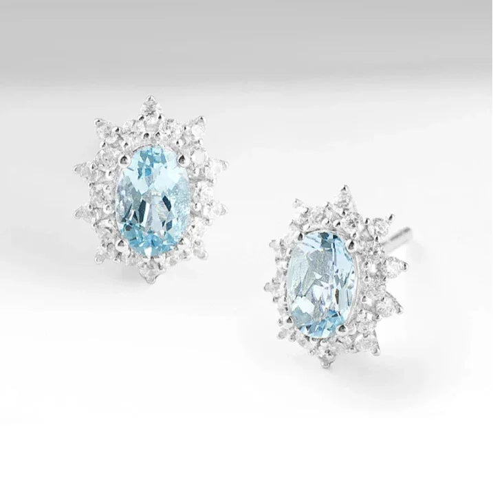 Oval Aquamarine Starburst Halo Stud Earrings angled pair on a white background