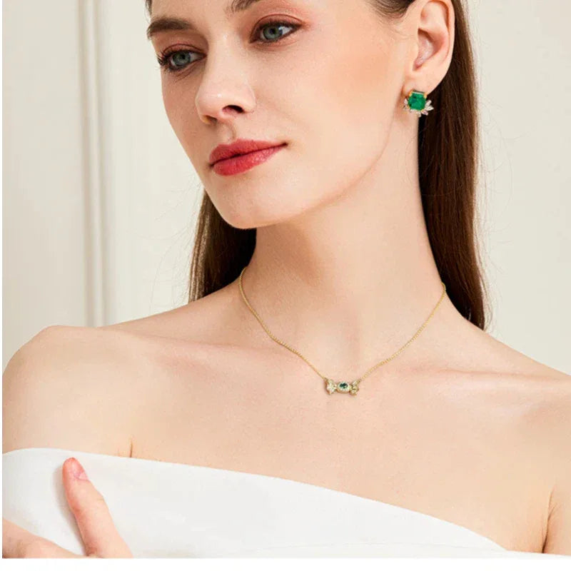 Oval Emerald Butterfly Necklace worn at the neckline in a close-up
