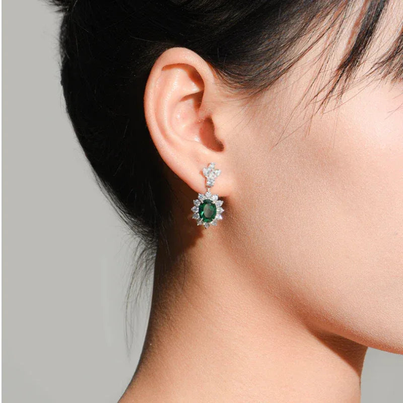 Oval Emerald Floral Drop Earrings worn on the ear from a second angle