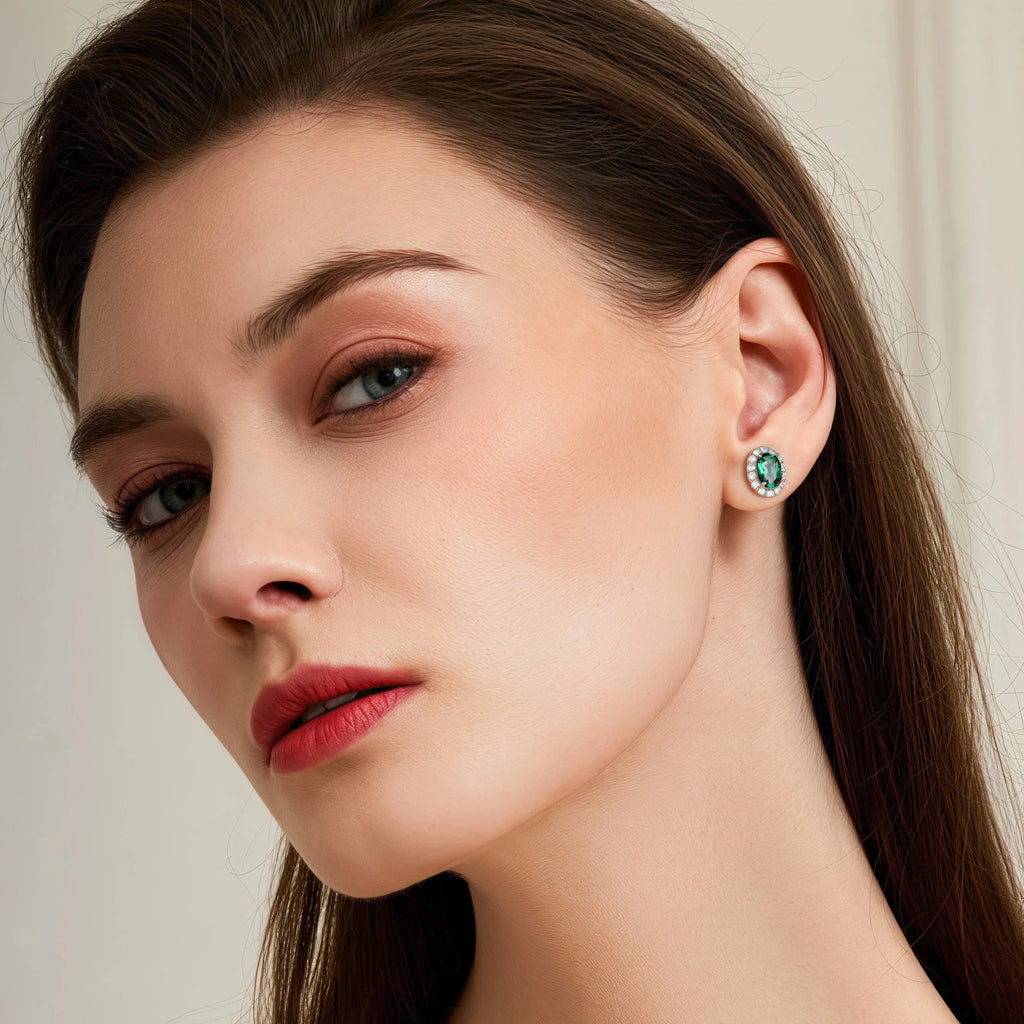 Oval Emerald Halo Stud Earrings worn on the ear from a second angle