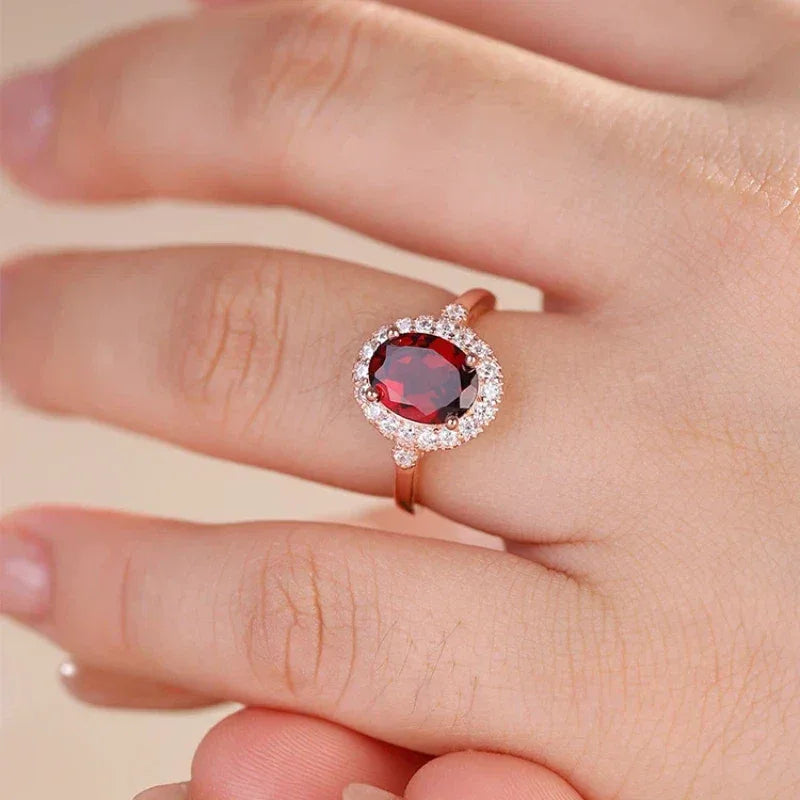 Oval Garnet Halo Adjustable Ring worn on the hand in a close-up