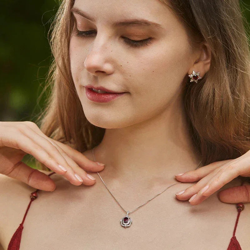 Oval Garnet Ornate Pendant Necklace worn at the neckline in a close-up