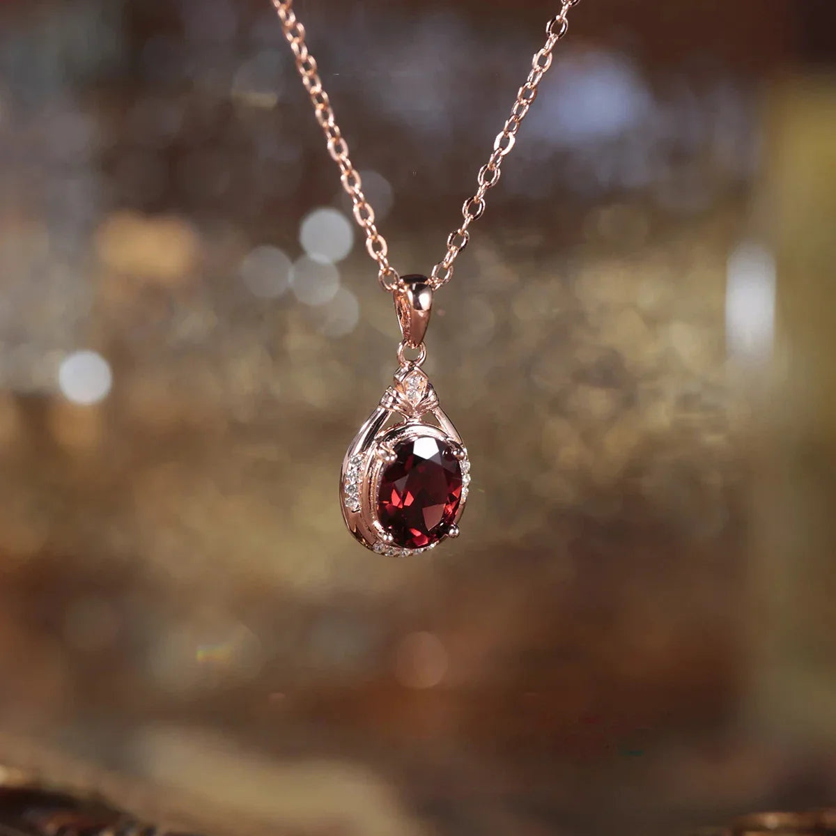 Oval Garnet Teardrop Pendant Necklace worn at the neckline in a close-up