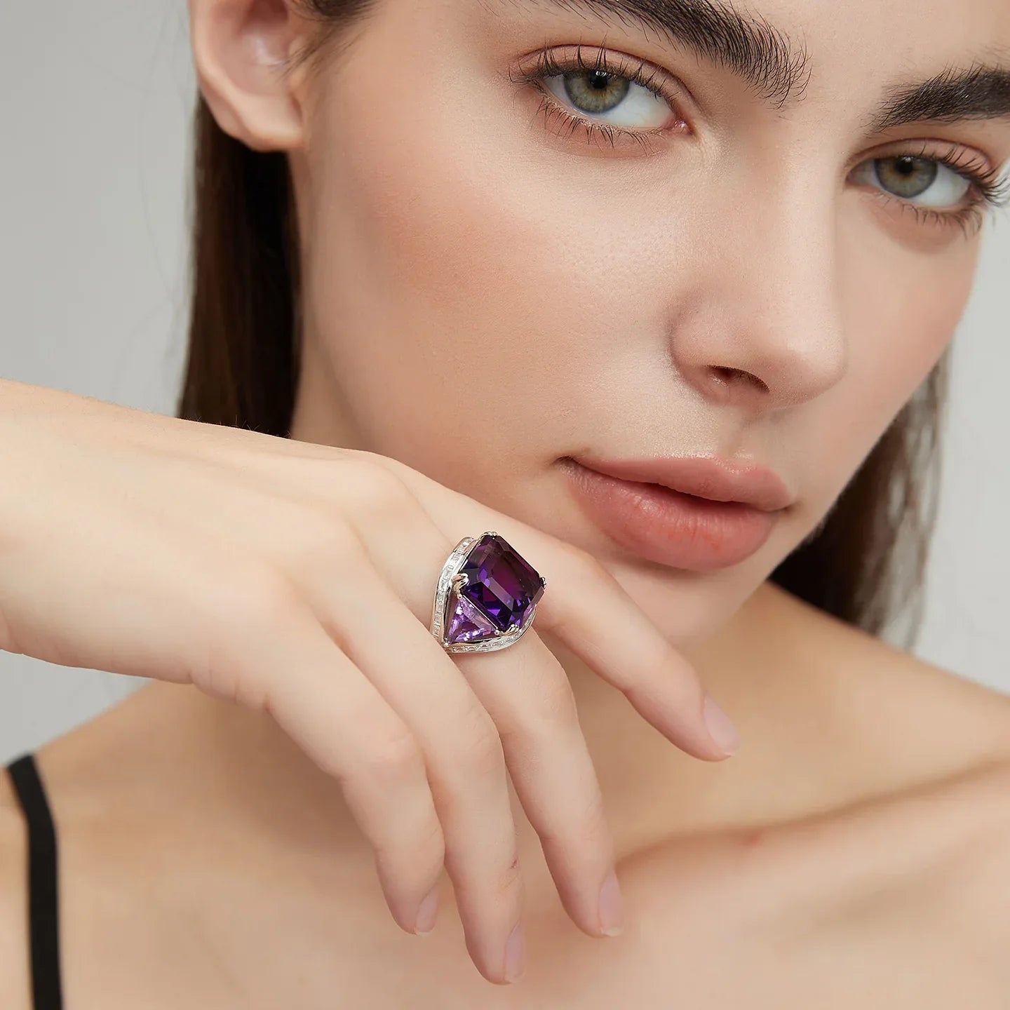 oversized amethyst open ring worn on the hand in a close-up