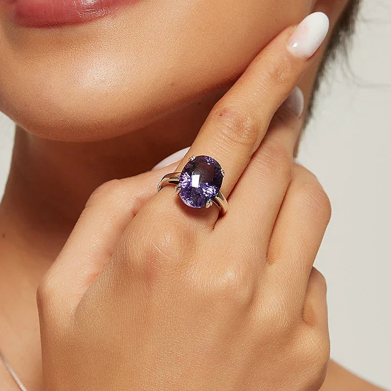 oversized oval amethyst ring worn on the hand in a close-up