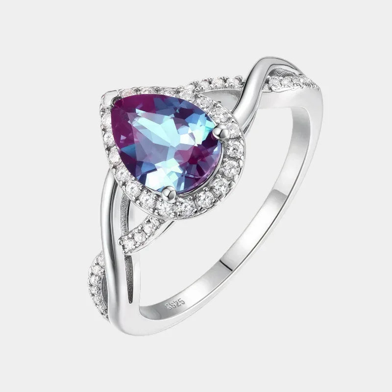 Pear-cut Alexandrite halo ring with a sweeping bypass band, front product view on a white background