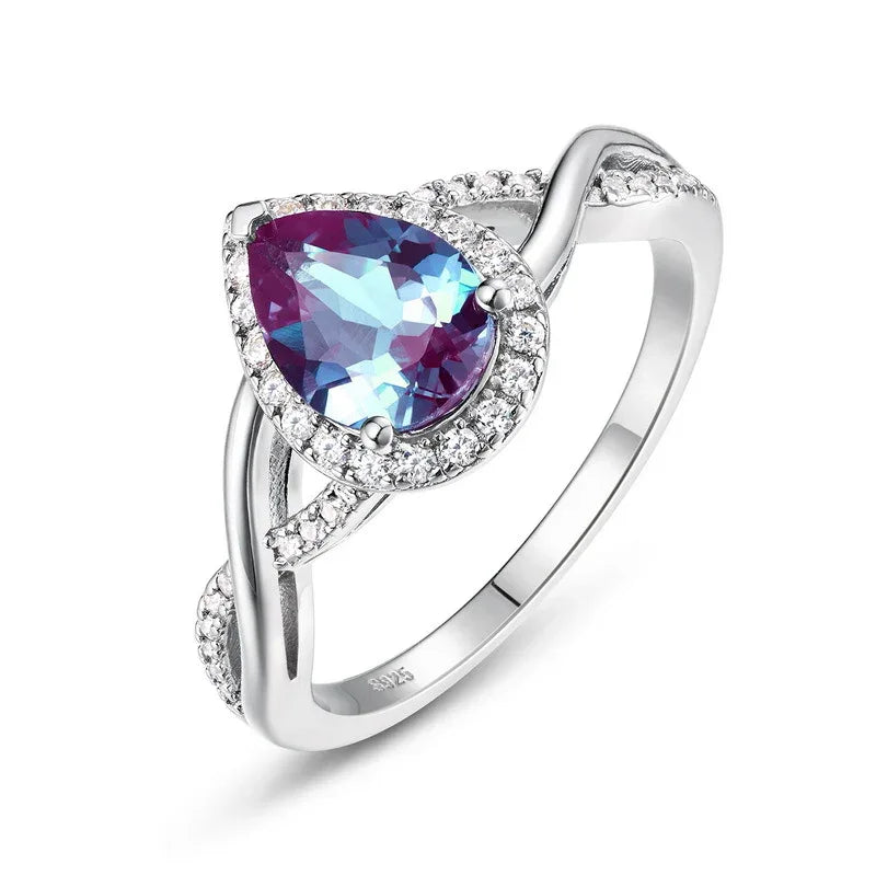 Pear-cut Alexandrite halo ring with a sweeping bypass band, alternate front product view on a white background