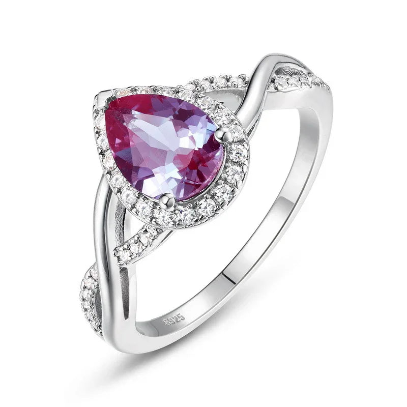 Pear-cut Alexandrite halo ring with a sweeping bypass band, alternate pink-toned Alexandrite view under alternate lighting