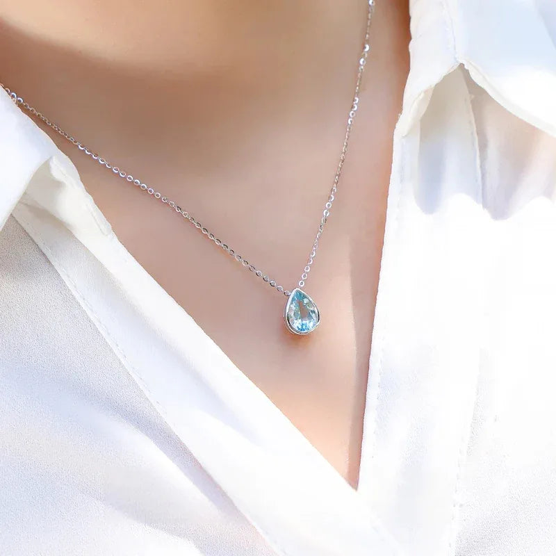 Pear-Cut Aquamarine Bezel Pendant Necklace worn at the neckline in a close-up