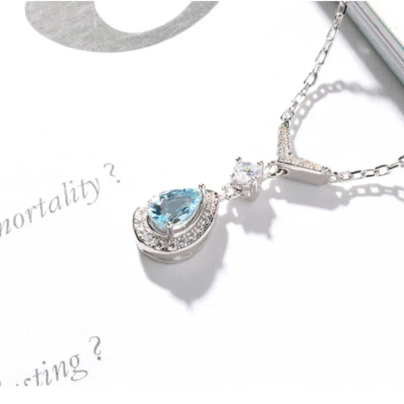 Pear-Cut Aquamarine Halo Drop Necklace pendant and chain detail on a light background