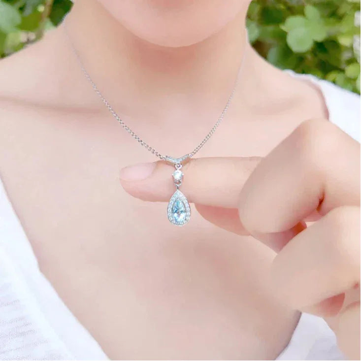 Pear-Cut Aquamarine Halo Drop Necklace worn at the neckline in a close-up