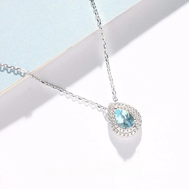Pear-Cut Aquamarine Halo Pendant Necklace angled pendant detail on white