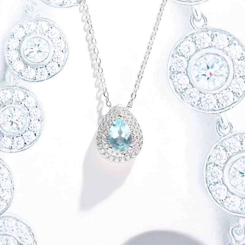 Pear-Cut Aquamarine Halo Pendant Necklace pendant and chain detail on a light background
