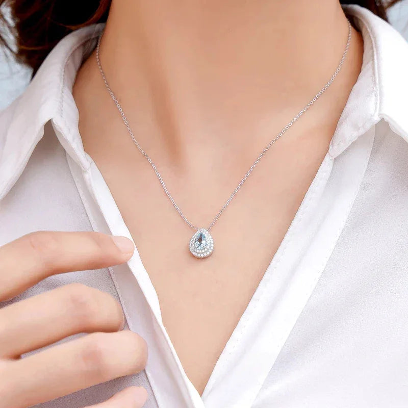 Pear-Cut Aquamarine Halo Pendant Necklace worn at the neckline in a close-up