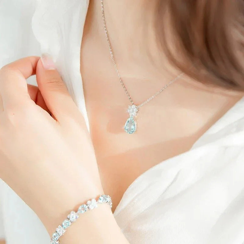 Pear-Cut Aquamarine Snowflake Drop Necklace worn at the neckline in a close-up