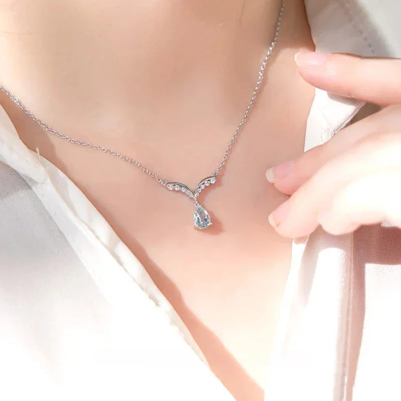 Pear-Cut Aquamarine Wing Pendant Necklace worn at the neckline in a close-up