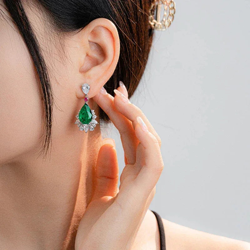 Pear-Cut Emerald and Pink Accent Drop Earrings worn on the ear in a close-up