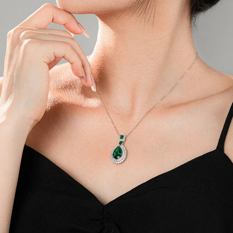 Pear-Cut Emerald Double-Halo Pendant Necklace worn at the neckline in a close-up