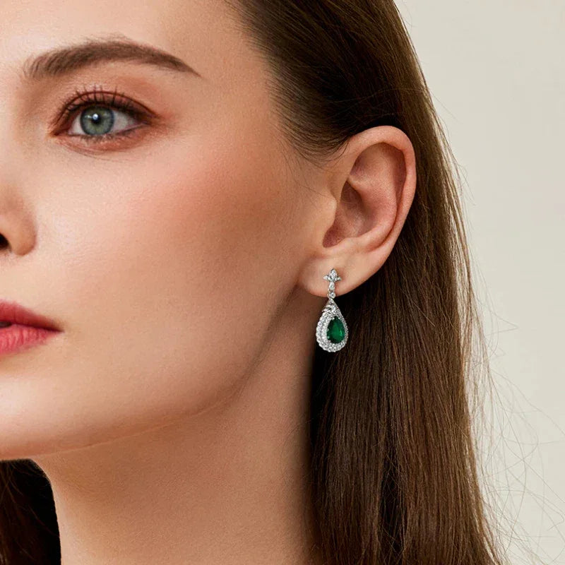 Pear-Cut Emerald Halo Drop Earrings styled ear view showing scale