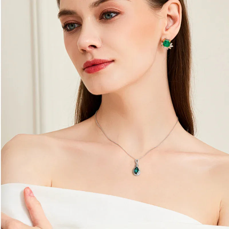 Pear-Cut Emerald Halo Pendant Necklace worn at the neckline in a close-up