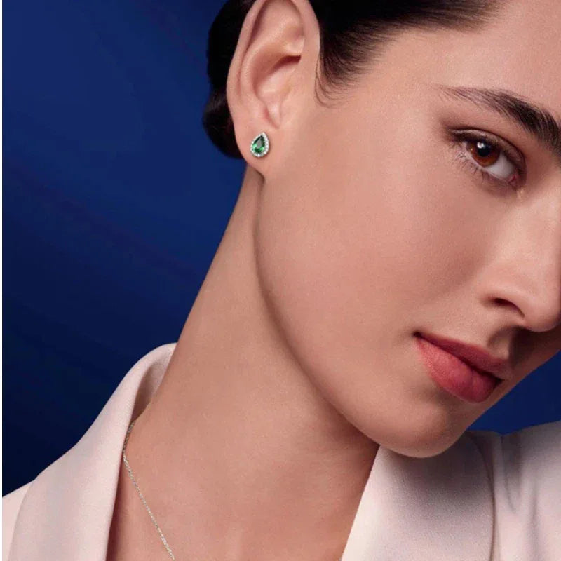 Pear-Cut Emerald Halo Stud Earrings styled ear view showing scale