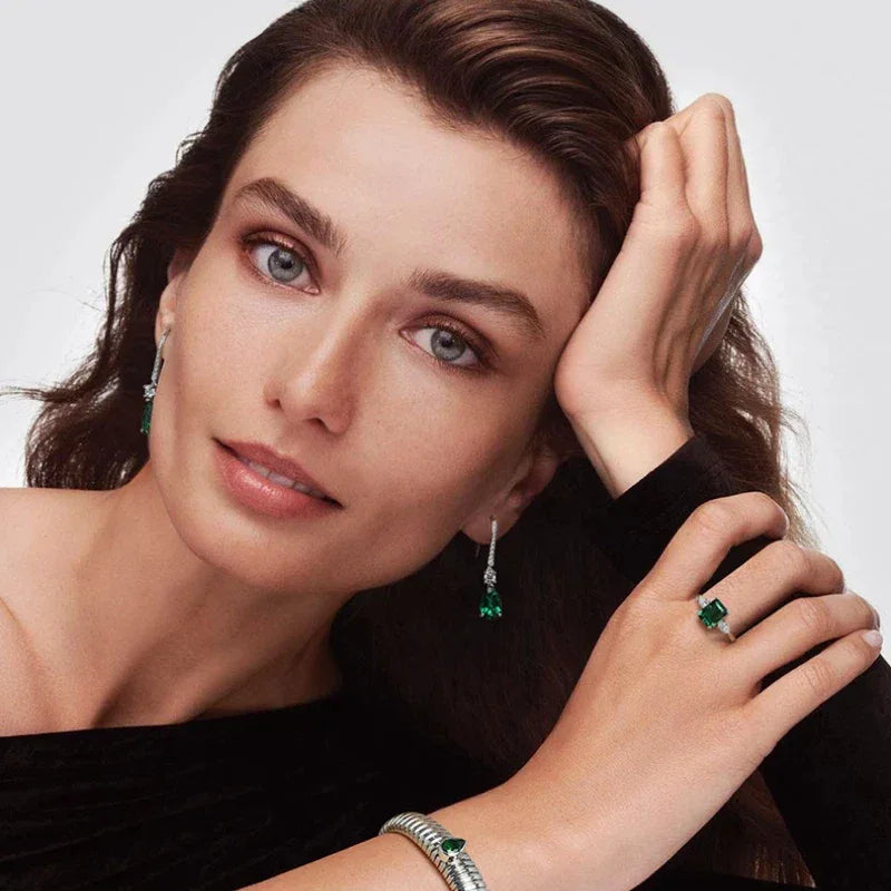 Pear-Cut Emerald Long Drop Earrings worn on the ear in a close-up