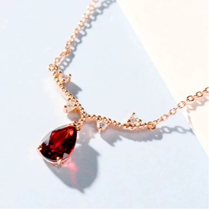 Pear-Cut Garnet Drop Necklace pendant styled on a jewelry display