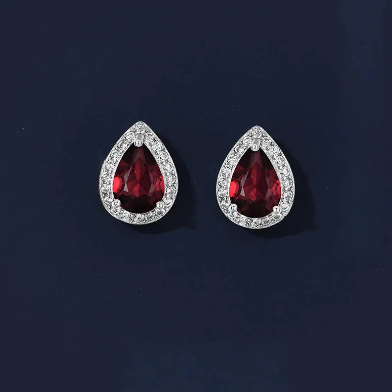 Pear-Cut Garnet Halo Stud Earrings angled product detail on a jewelry display