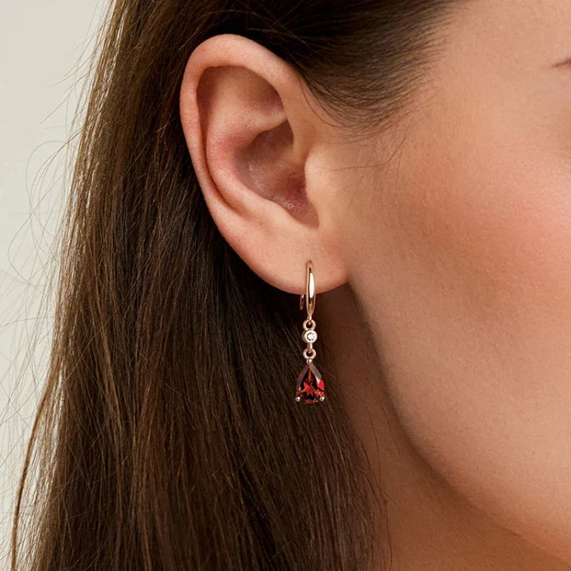 Pear-Cut Garnet Hook Drop Earrings side view held between the fingers