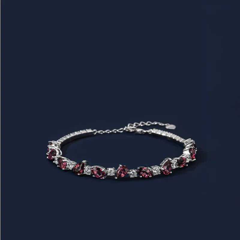 Pear-Cut Garnet Tennis Bracelet full bracelet view on a dark background