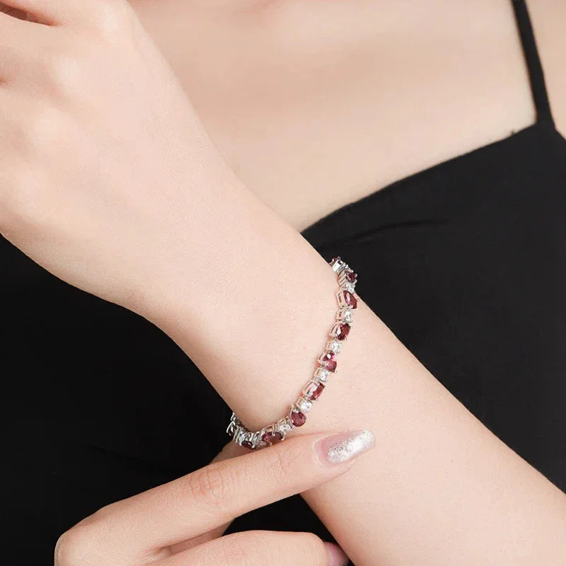 Pear-Cut Garnet Tennis Bracelet worn on the wrist in a close-up