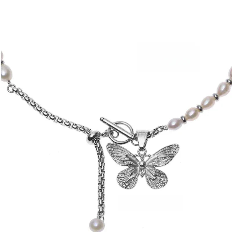 Pearl and Tiger Eye Butterfly Necklace — macro view of the openwork butterfly and slim hanging charm