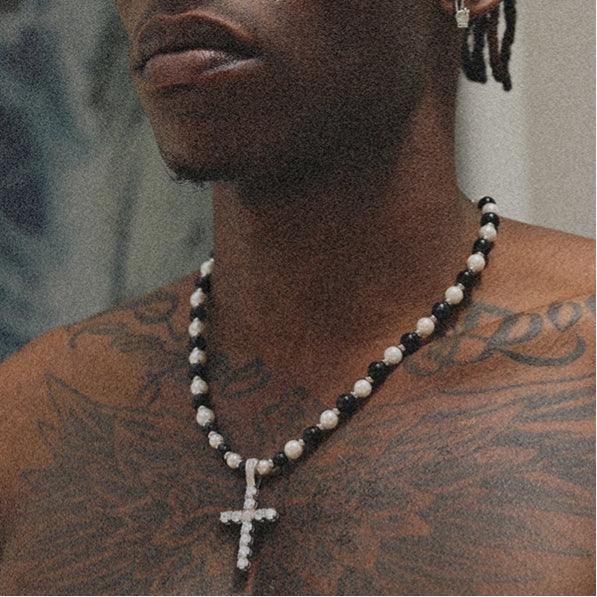 Pearl and Tiger Eye Cross Necklace — model wearing the necklace over a bare chest
