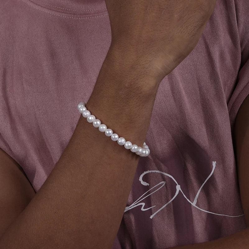 Adjustable Pearl Strand Bracelet — closer wrist-worn view over a muted pink shirt