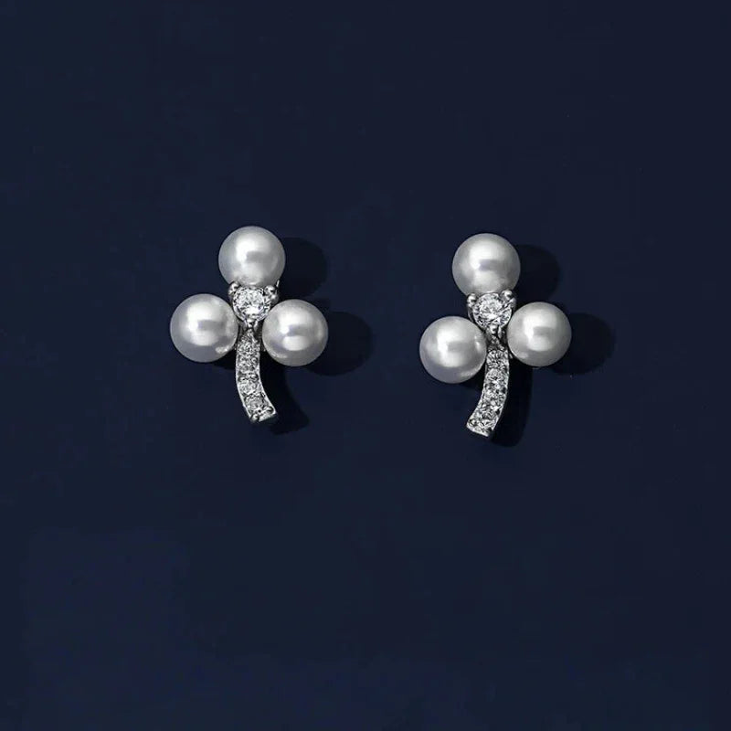 Three-Pearl Bow Stud Earrings in Platinum-Plated S925 Silver — pair displayed on a dark background