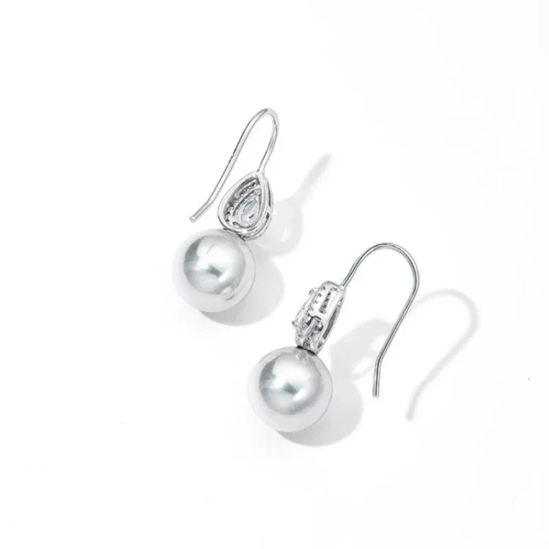 Pearl Teardrop Halo Earrings — angled pair on white showing the hook wires