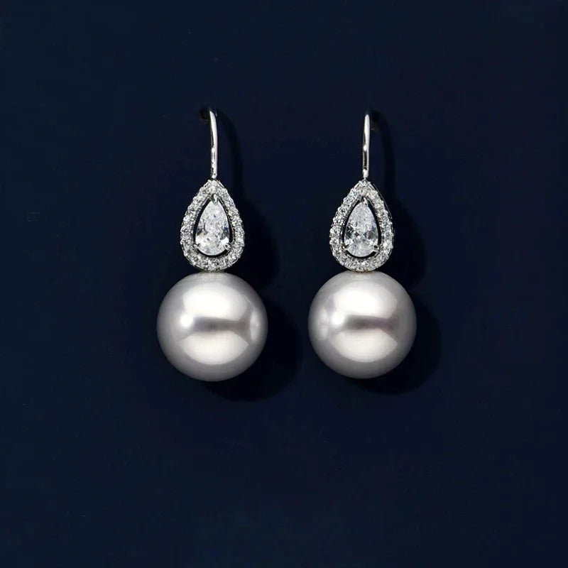 Pearl Teardrop Halo Earrings — pair displayed on a dark background