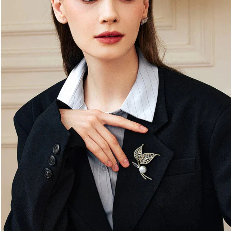 Pearl Double-Leaf Brooch — waist-up blazer-worn portrait beside the model's hand