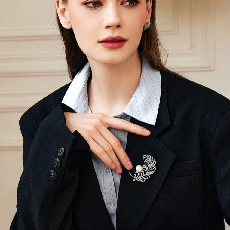 Pearl Feather Brooch — waist-up model view with the brooch pinned on a dark blazer