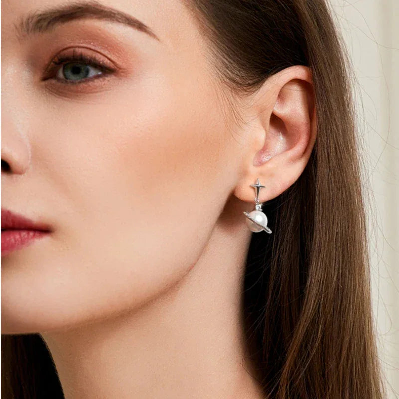 Moon and Star Pearl Planet Drop Earrings — right-ear worn portrait showing the star earring