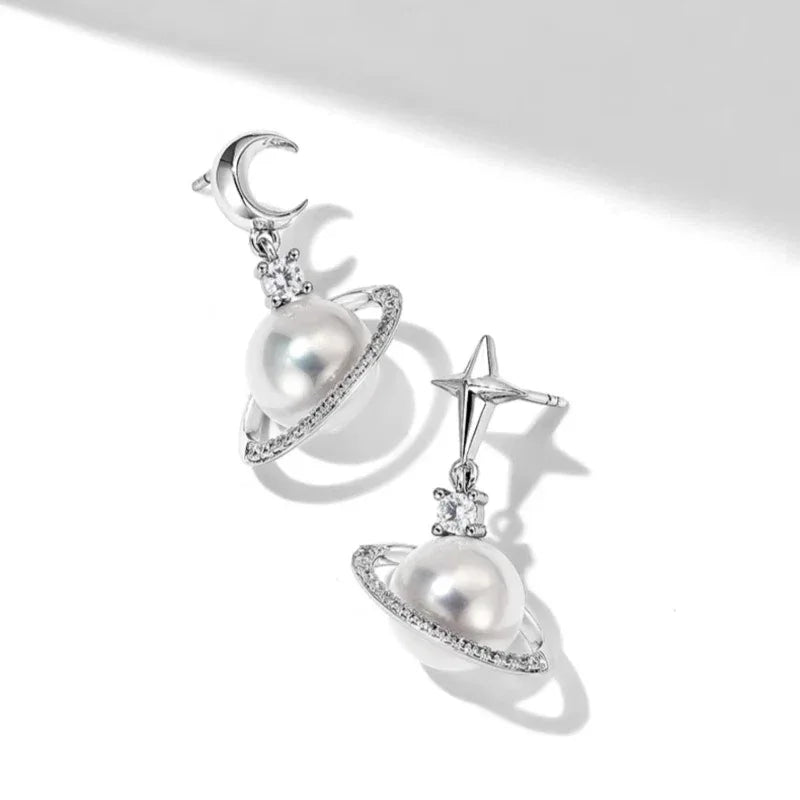 Moon and Star Pearl Planet Drop Earrings — angled pair on white showing the sculptural planet rings