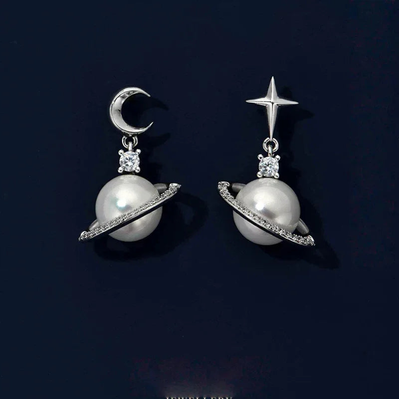 Moon and Star Pearl Planet Drop Earrings — pair displayed on a dark background