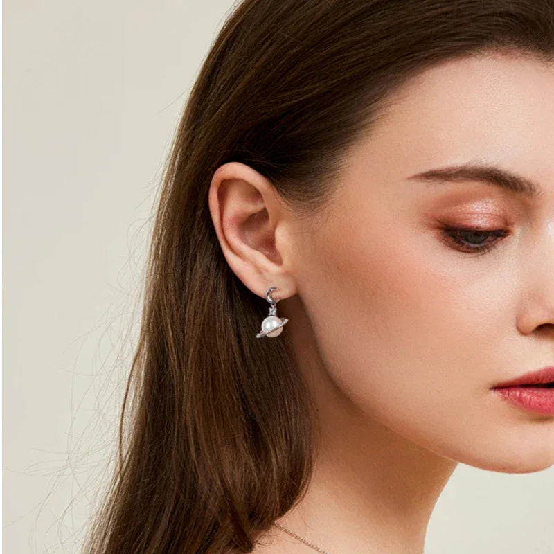 Moon and Star Pearl Planet Drop Earrings — left-ear worn portrait with the face angled downward