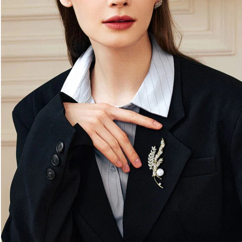 Pearl Wheat Sprig Brooch — waist-up model view with the brooch pinned on a dark blazer
