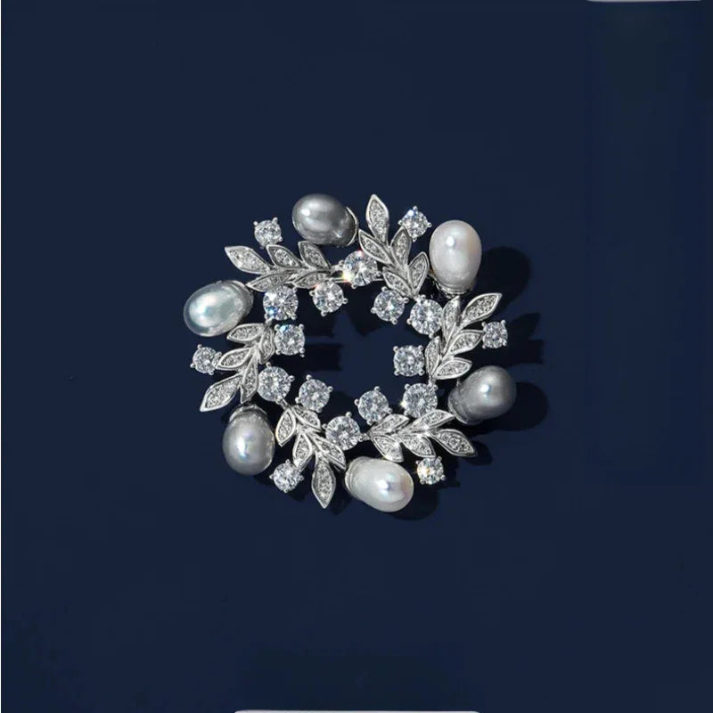 Pearl and Cubic Zirconia Olive Leaf Wreath Brooch — front product view on a dark background
