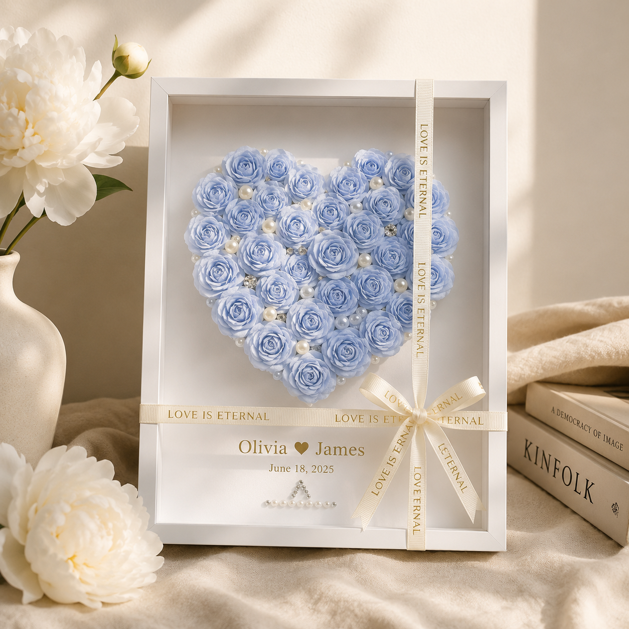 Personalized blue paper rose heart shadow box displayed on a walnut console table beside a lit candle champagne flute