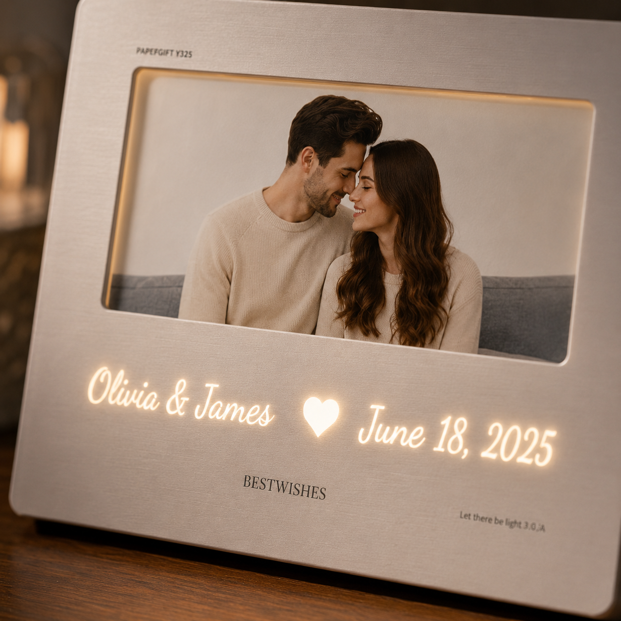 Close-up of personalized hidden message film card LED light frame in matte silver showing couple photo with warm white